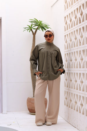 Olive-colored THT GIRL Lady Blouse with long sleeves and a relaxed fit, displayed on a hanger.