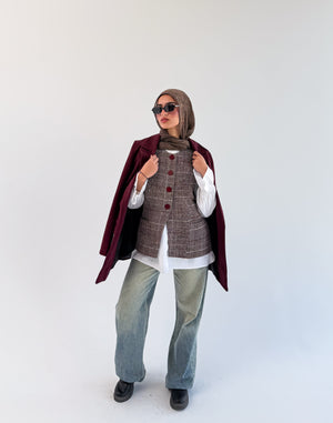 THT GIRL London Burgundy Check Vest displayed on a hanger, showcasing its stylish check pattern and classic design.