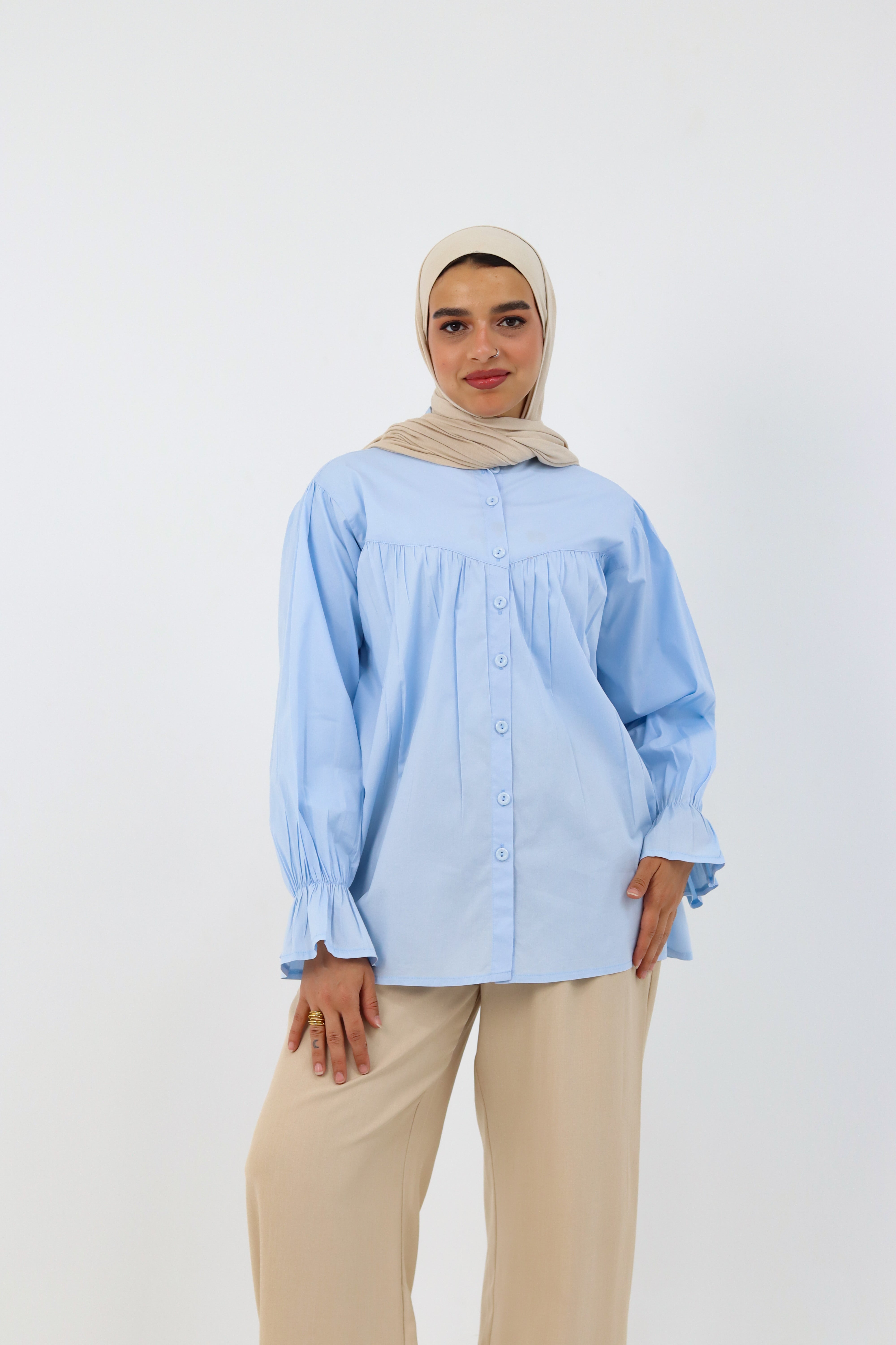 Baby blue THT GIRL Lady Blouse displayed on a hanger, featuring a stylish, lightweight design with long sleeves and a rounded neckline.