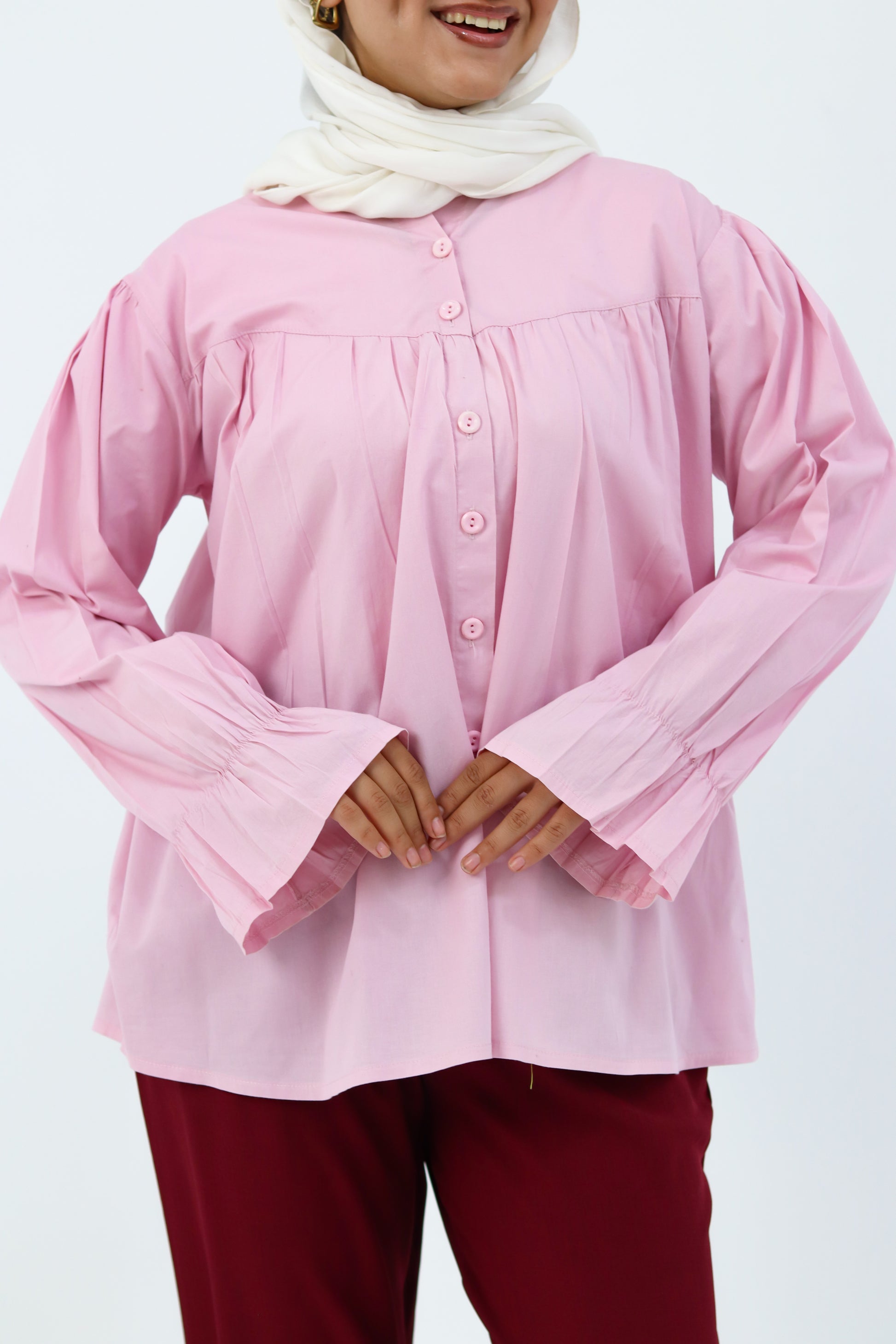 Baby pink THT GIRL Lady Blouse with long sleeves and ruffle details, displayed on a hanger against a neutral background.