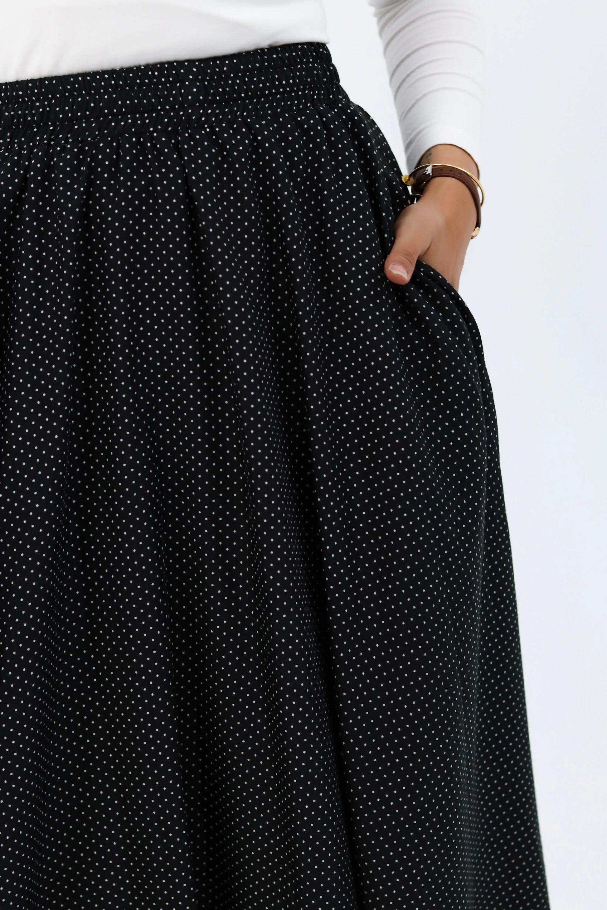 Black Riviera skirt from THT GIRL paired with a stylish blouse, shown in a fashion photograph.
