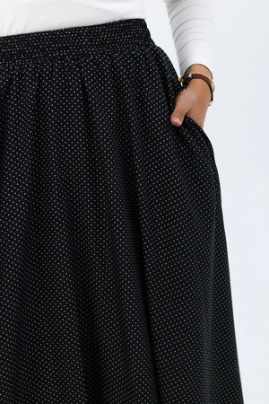 Black Riviera skirt from THT GIRL paired with a stylish blouse, shown in a fashion photograph.