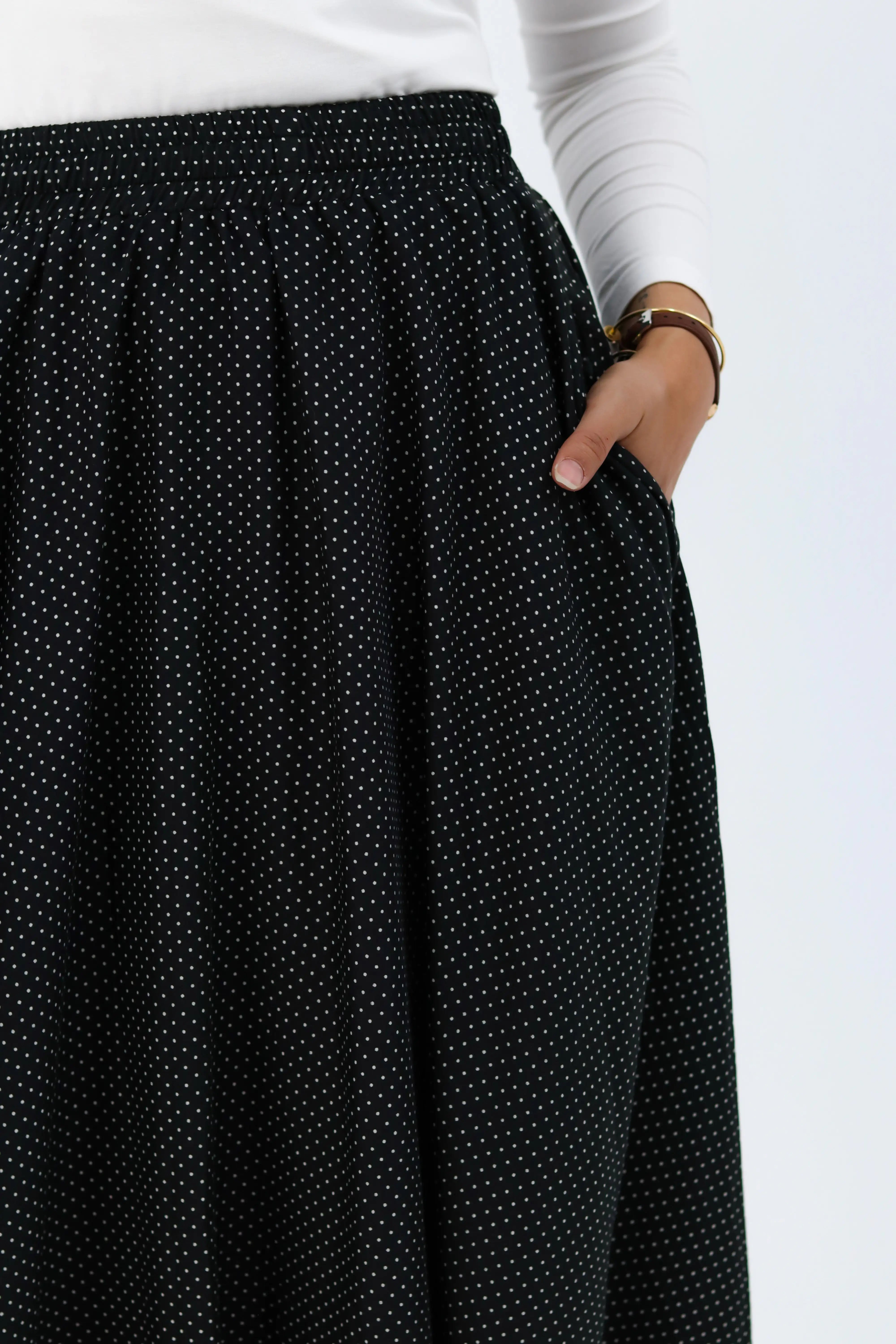 Black Riviera THT GIRL blouse with stylish design, displayed on a hanger against a neutral background.