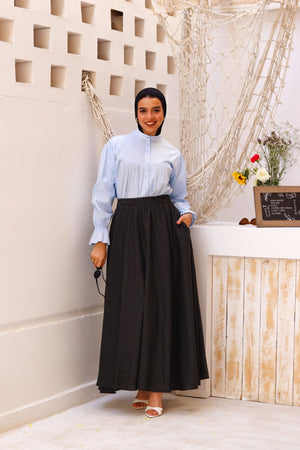 Black Riviera skirt paired with a THT Girl blouse, showcasing a stylish fashion ensemble.