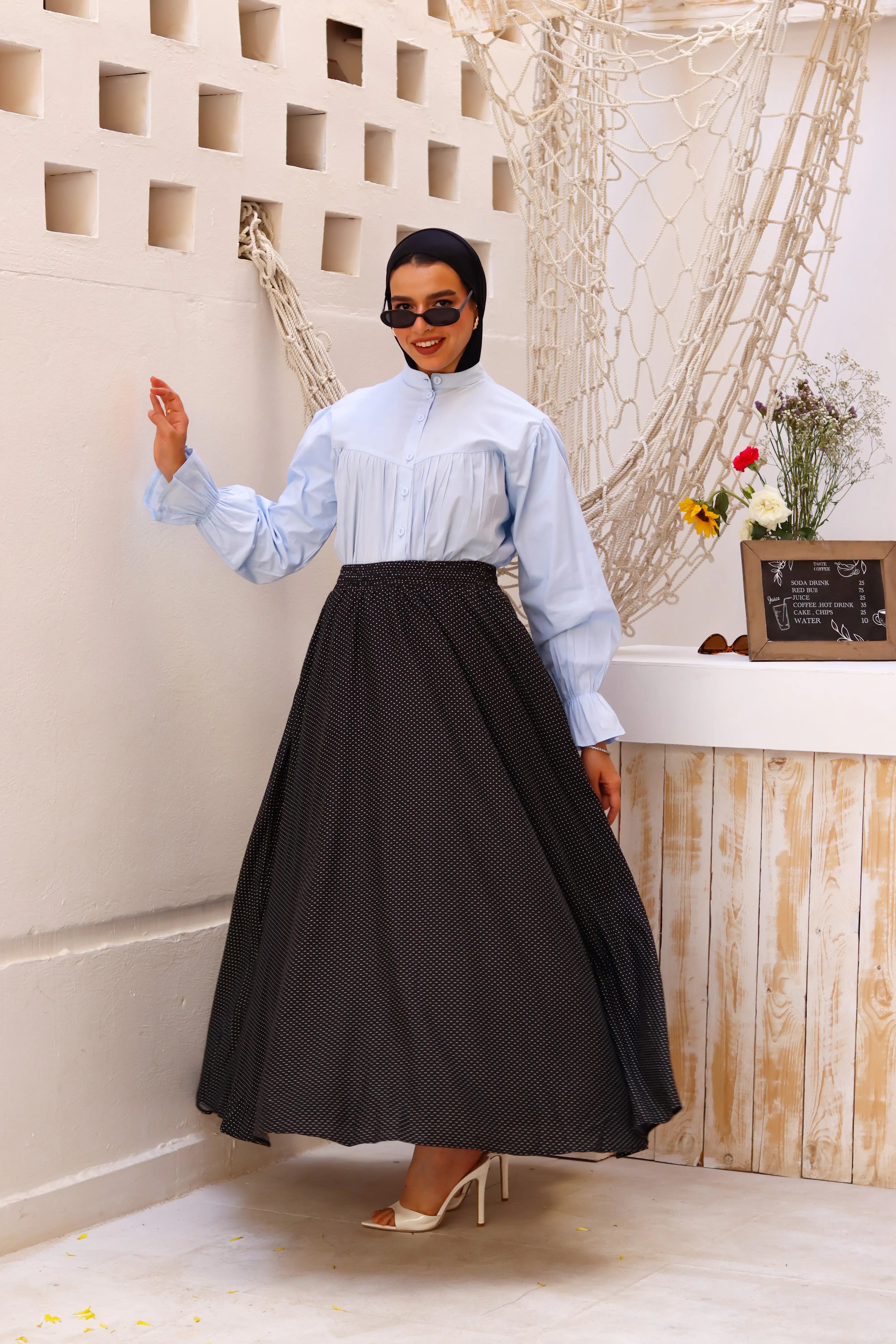 THT GIRL Riviera black skirt paired with a stylish blouse, shown in a well-lit image showcasing the outfit's details and fabric.