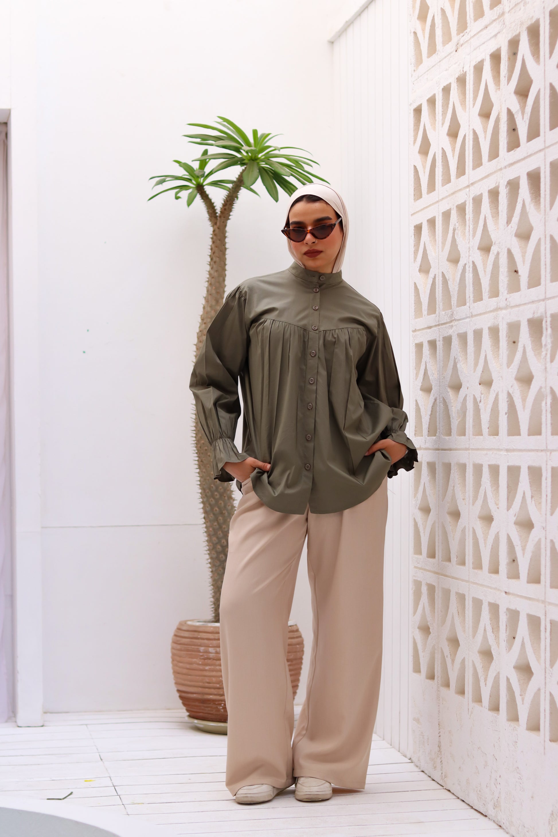 Olive-colored THT GIRL Lady Blouse with long sleeves and a relaxed fit, displayed on a hanger.