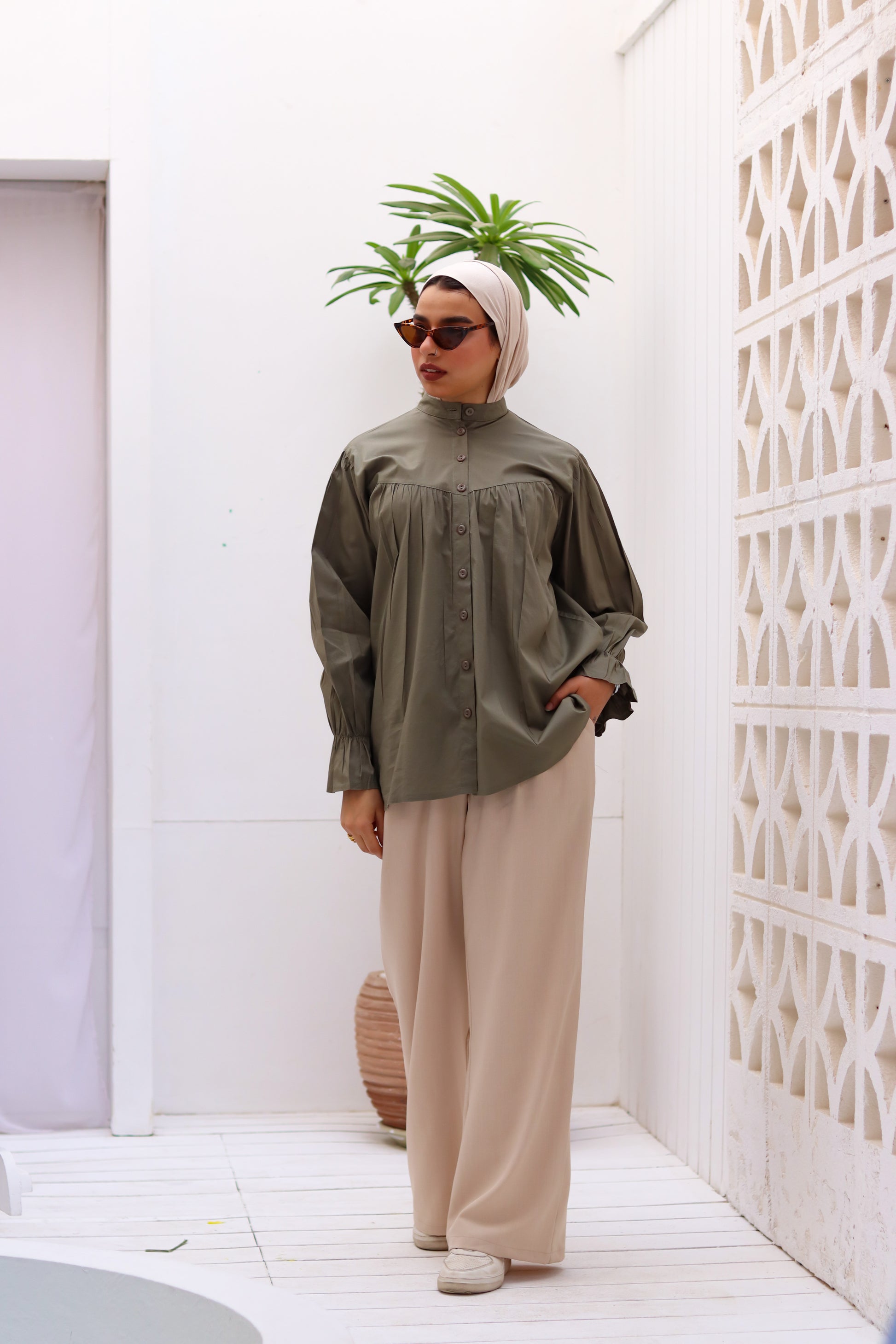 Olive THT GIRL Lady Blouse displayed on a hanger, showcasing its elegant design and fabric details.