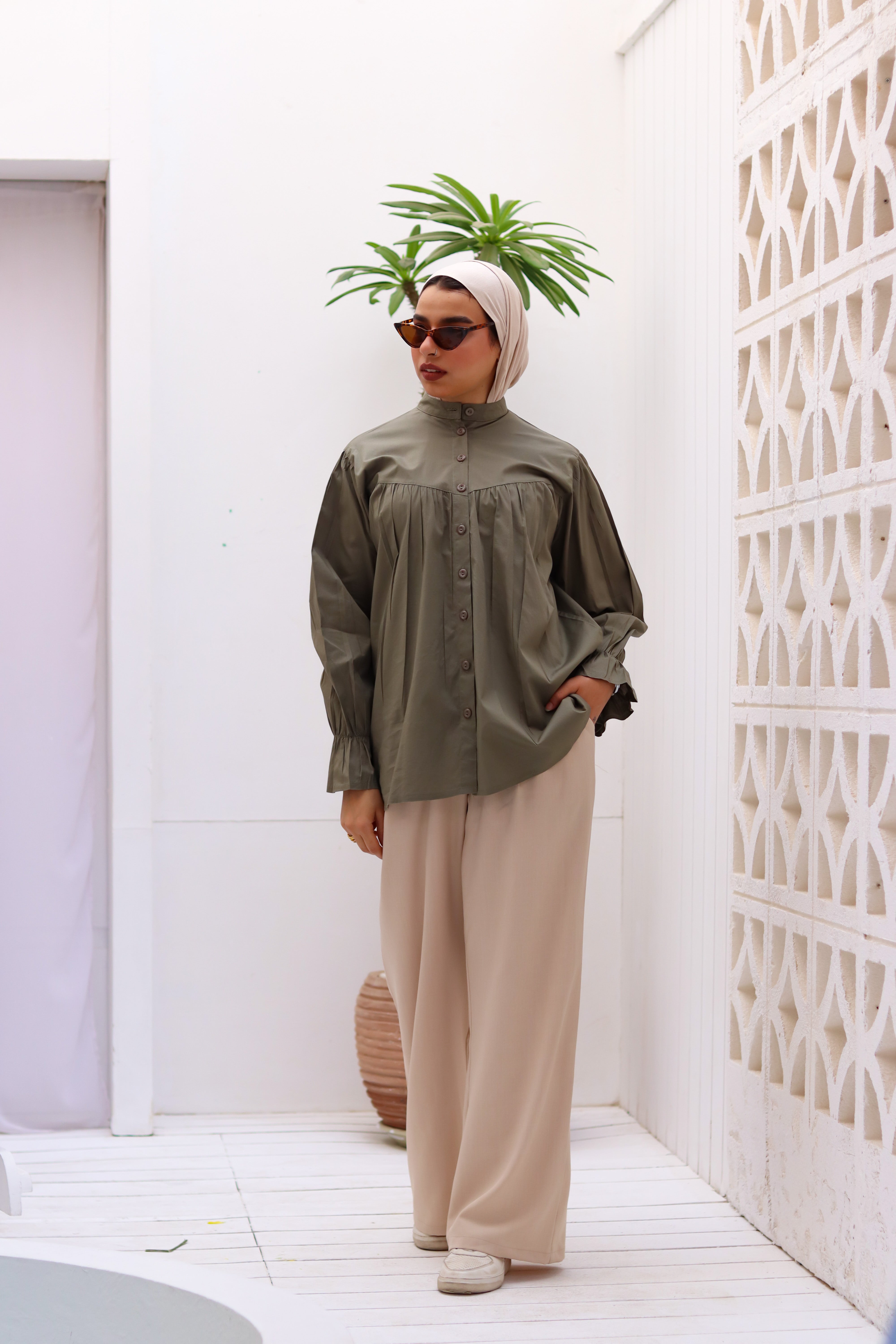 Olive THT GIRL Lady Blouse displayed on a hanger, showcasing its elegant design and fabric details.